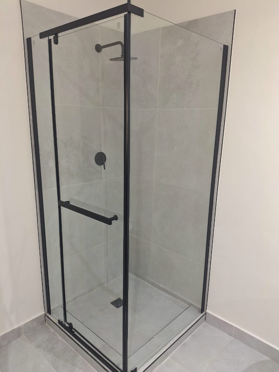 Framed glass shower installation during bathroom renovation