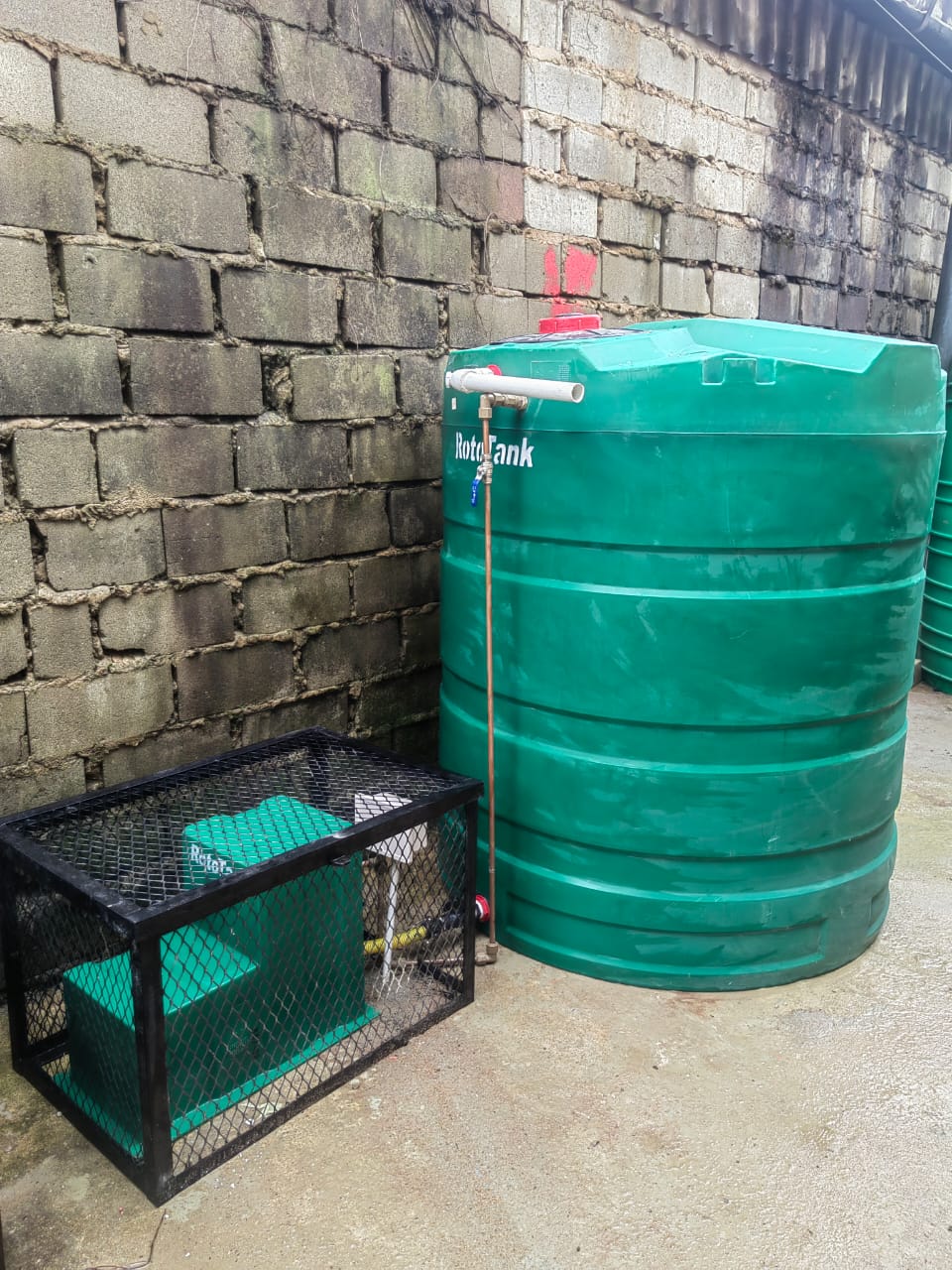 Backup water storage tank with protected pump housing